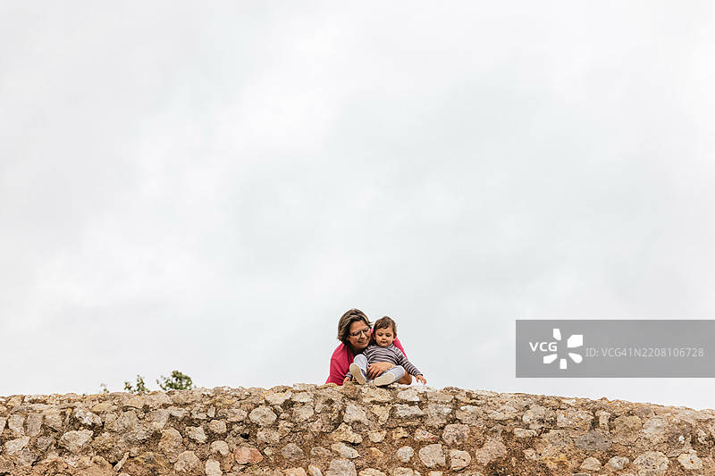 母亲和婴儿儿子在马洛卡的波连萨罗马桥上欣赏美景图片素材