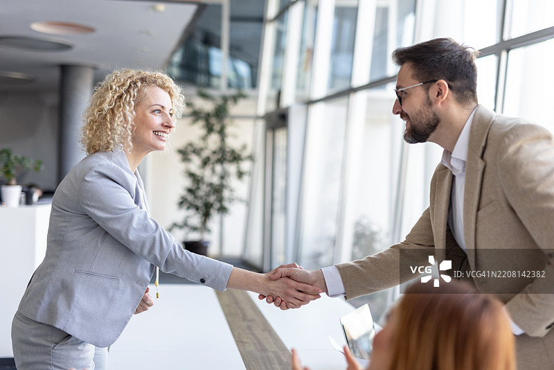 两位快乐的商业伙伴之间的专业握手。图片素材