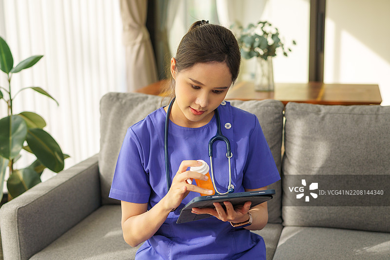 女性家庭健康护理专业人员使用平板电脑记录患者健康历史。图片素材