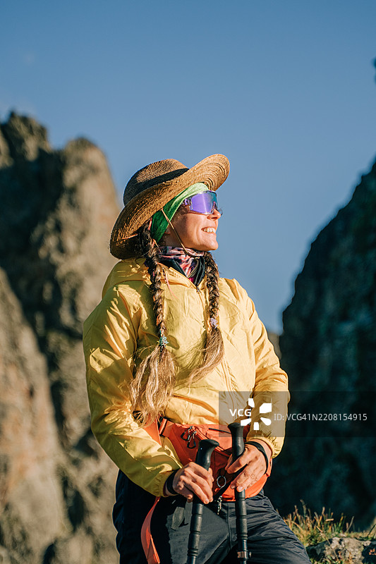微笑的女性徒步旅行者享受山景图片素材