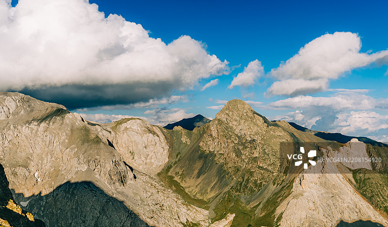 雄伟的山峰在云层下向天空伸展图片素材