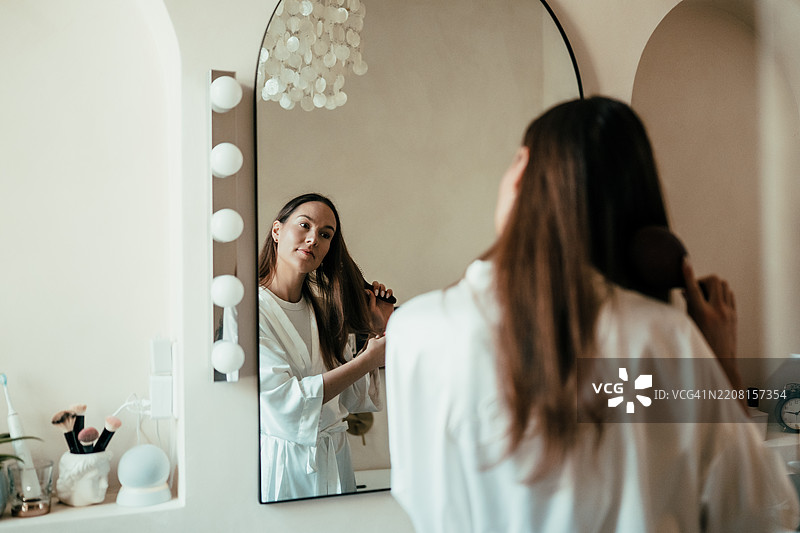 早上，女人在浴室里梳理头发图片素材