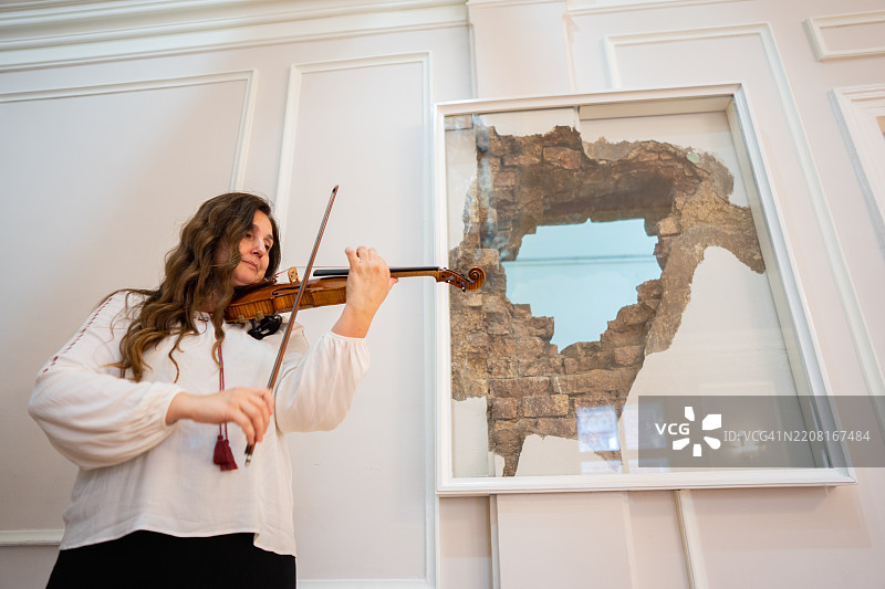 成熟的女性在音乐学院演奏小提琴图片素材