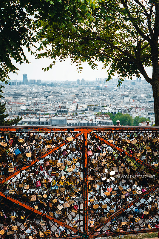城市上方的栅栏上的爱情锁图片素材