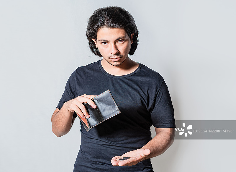 面临财务危机的人手持钱包，孤独的悲伤男子拿着空钱包，身处尼加拉瓜马那瓜。图片素材