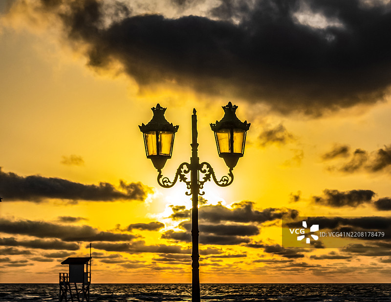 日落时分，街灯的剪影映衬在天空中图片素材