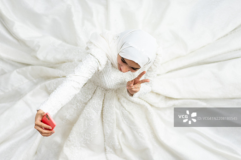 年轻的穆斯林新娘穿着婚纱自拍图片素材