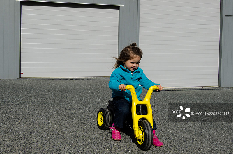 可爱的小女孩骑着三轮车图片素材
