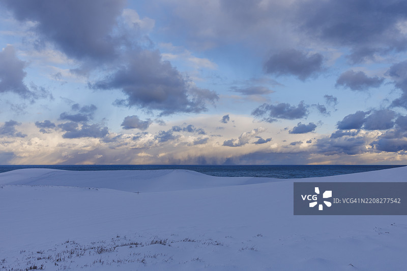 鸟取沙丘在雪中，蓝天和美丽的云朵相映成趣图片素材