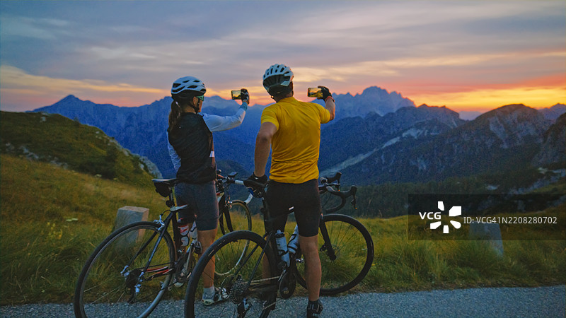 骑行情侣在阿尔卑斯公路冒险中拍摄山间日落图片素材