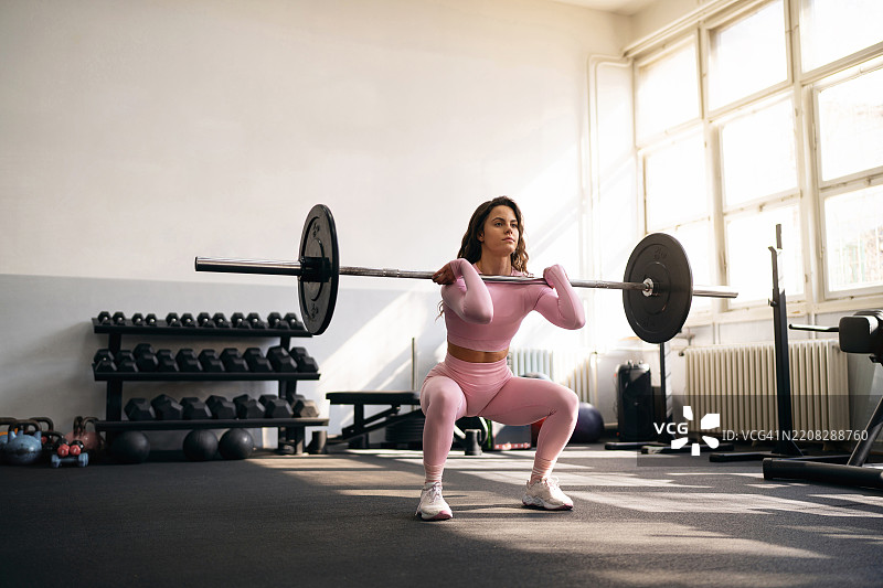 年轻女性在健身房锻炼图片素材