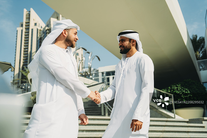 两位阿拉伯商人在迪拜握手图片素材