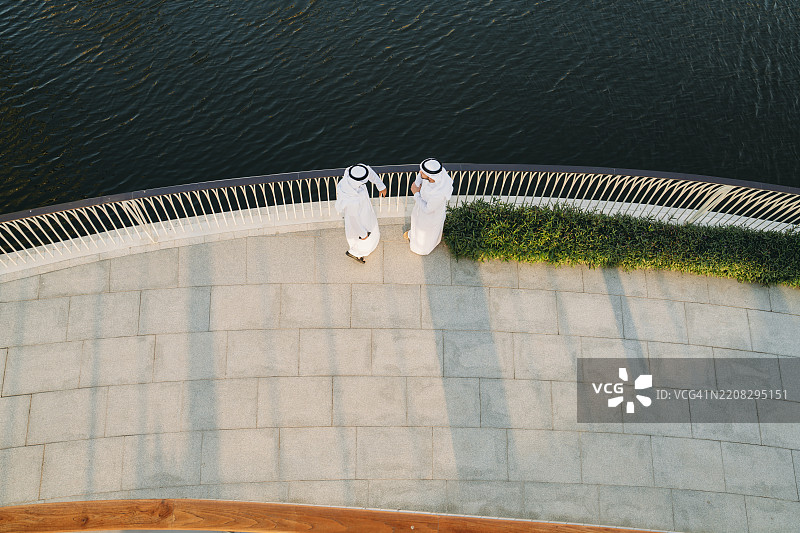 两位阿拉伯商人在迪拜的一座桥上讨论图片素材