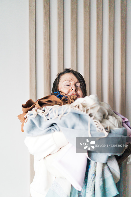 手里拿着一堆旧物品的快乐女性肖像。图片素材