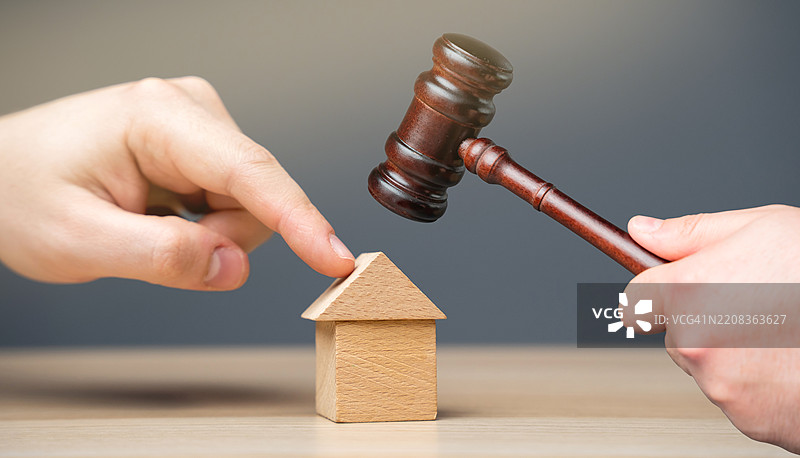 手放置木屋和法官的锤子 房地产法庭裁决 财产继承诉讼 所有权的确立图片素材