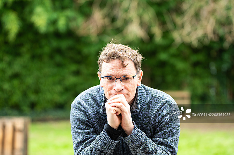 一位45岁的白人金发男性，穿着灰色毛衣，位于比利时布鲁塞尔的科克尔贝格。图片素材