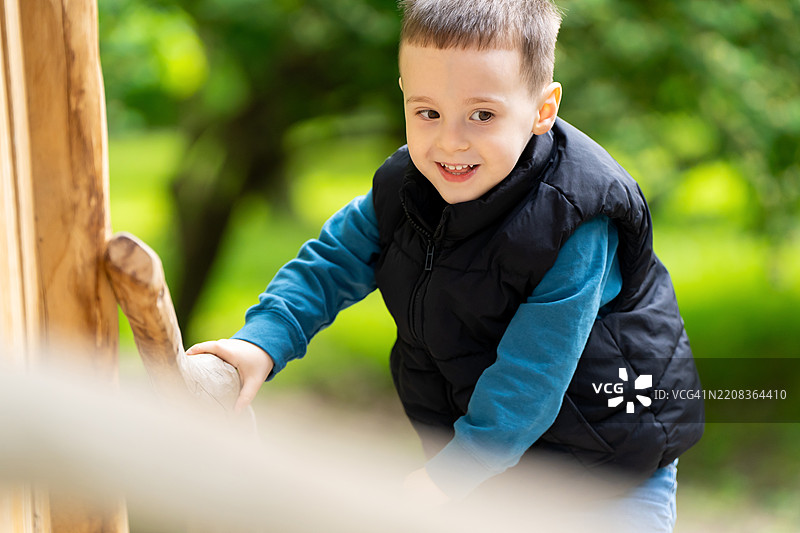 可爱的三岁快乐男孩在公园的游乐场玩耍，健康的春季儿童活动，儿童游戏图片素材