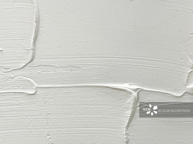 墙面上白色油漆的特写，带有刷痕图片素材