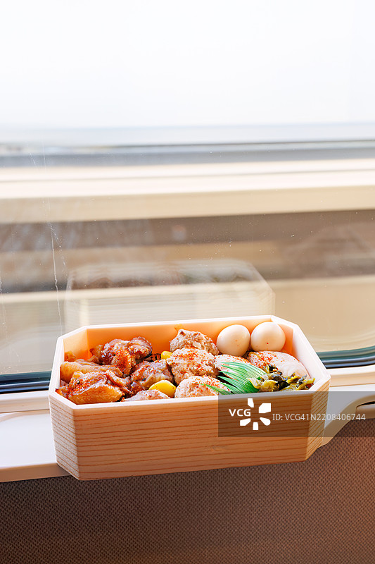 在预定座位上享用的烧鸟便当(在火车站出售的独特日本盒饭),搭配来自埼玉县川越市的当地啤酒。从大宫站搭乘前往新潟的上越新干线。大宫,埼玉 - 2024年11月30日图片素材