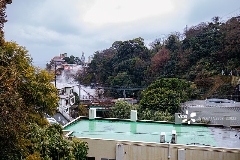 温泉通风口冒出的蒸汽，植物园建筑和停车场。图片素材
