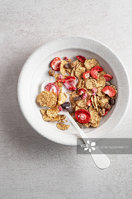 早餐碗里的玉米片和草莓。干草莓和玉米片。健康早餐选择：小麦片配干草莓。全谷物麦片加牛奶和干果。图片素材