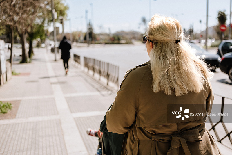 母亲推着婴儿车的背影图片素材