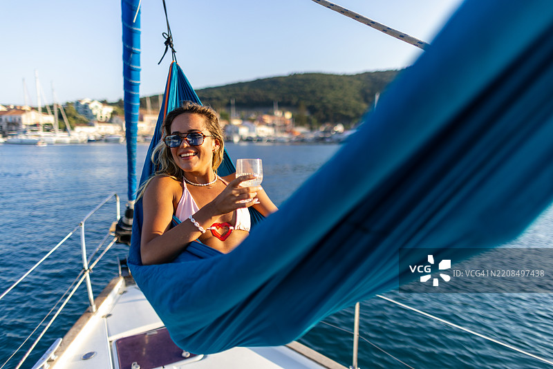 年轻女性在帆船上的吊床上放松图片素材