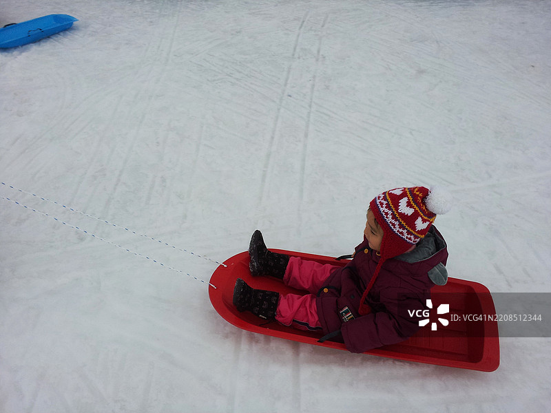 孩子在冬天享受滑雪橇的乐趣图片素材