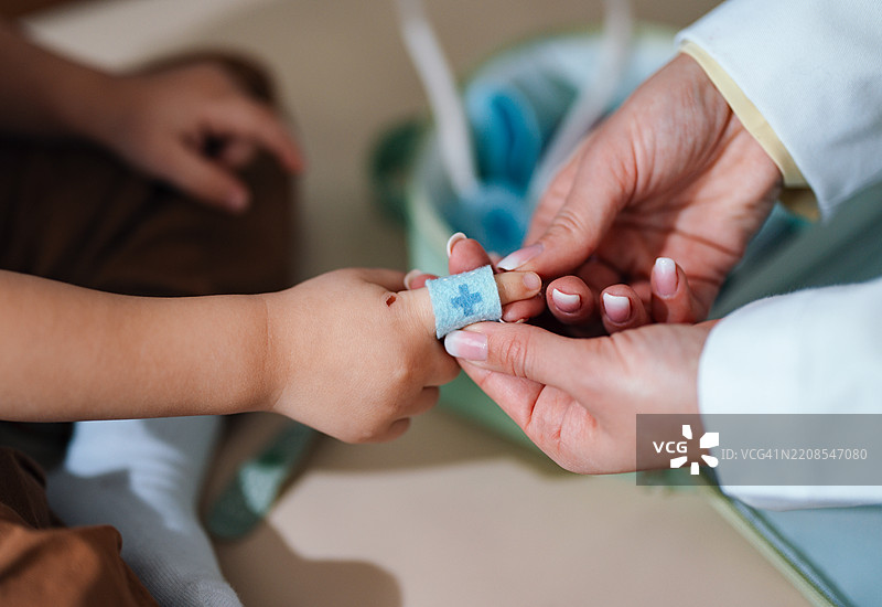 儿科医生在关怀的环境中照顾孩子受伤的手指图片素材