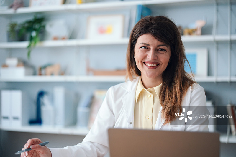 微笑的专业女性医生在有序的办公室环境中工作图片素材