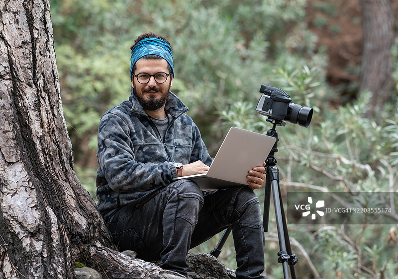 在户外使用笔记本电脑工作的自由摄影师图片素材