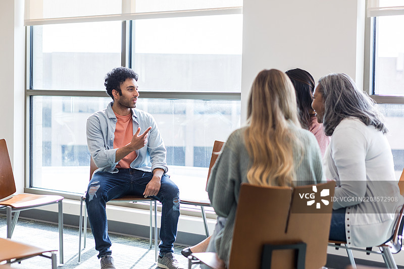 团体治疗会议：多元化的人们在交谈和倾听图片素材