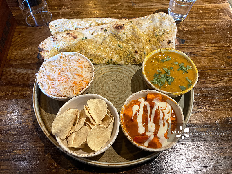 素食拼盘，包括黄扁豆达尔、奶酪烤饼马萨拉、大蒜烤饼、迷你薄脆饼和藏红花香米。图片素材