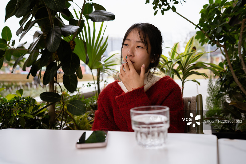 女人在户外咖啡馆享受时光。图片素材