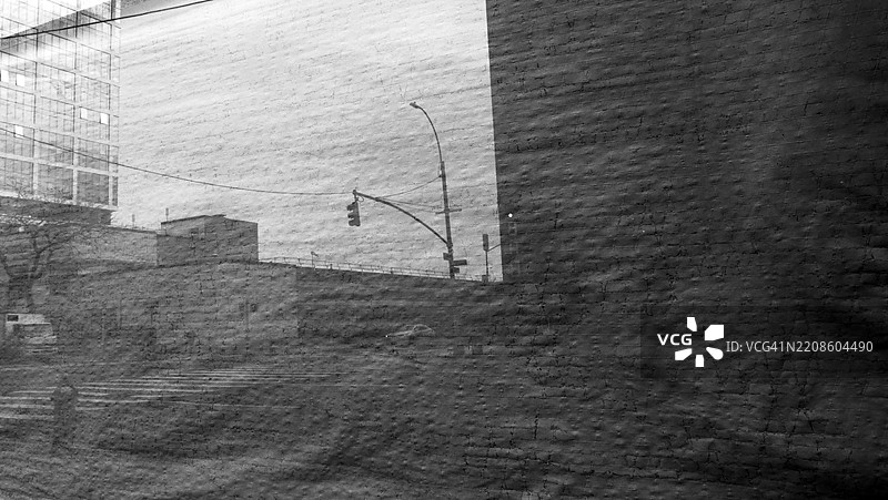 曼哈顿街道的抽象摄影(人行横道、汽车和卡车、建筑物、杆子和标志……)反射在窗户上,窗后有纹理纸。美国纽约州。图片素材