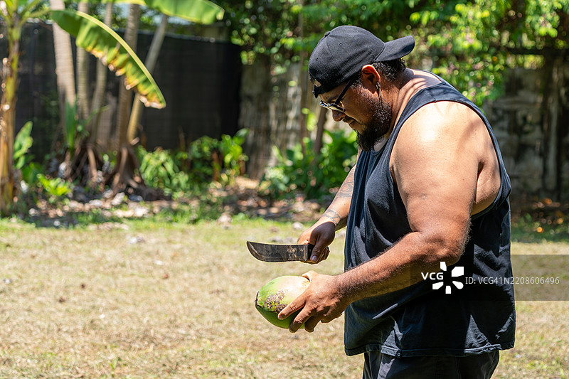 当地男子在哥斯达黎加乌维塔用砍刀打开新鲜椰子图片素材