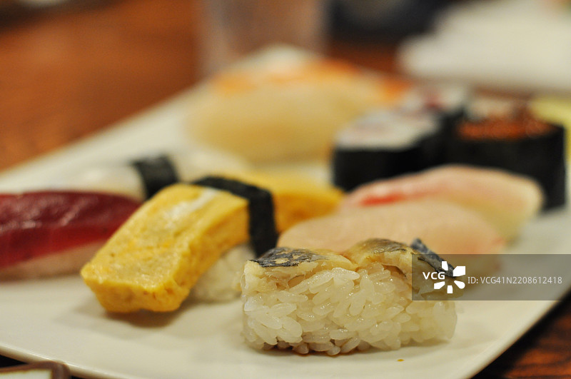 不同种类的新鲜寿司盛放在白色盘子上图片素材