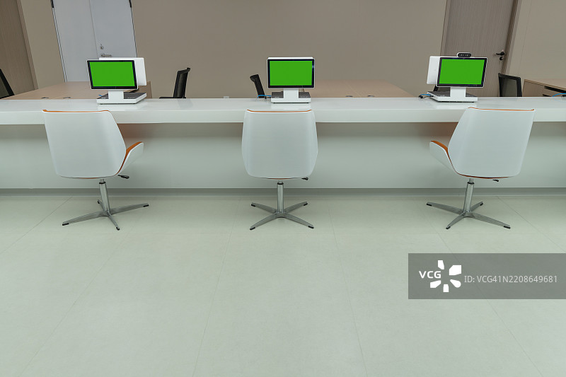 现代办公室工作区，配有三台电脑图片素材
