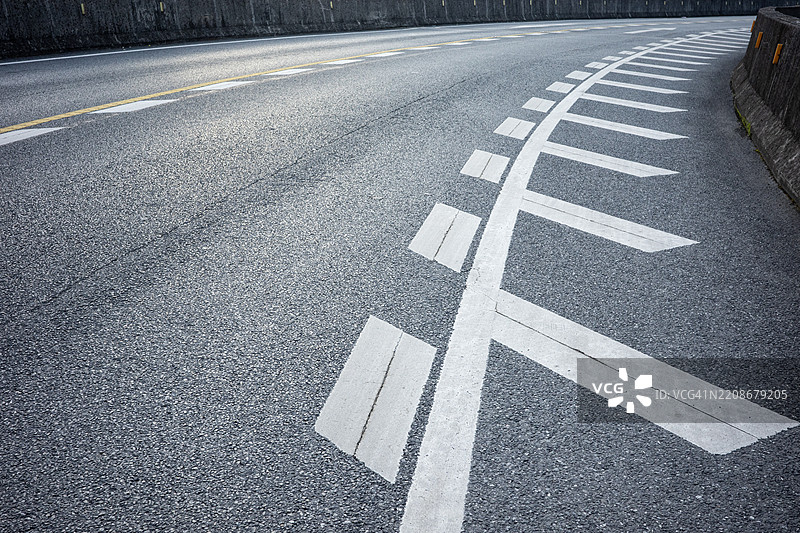 弯曲的城市道路与方向性车道标记图片素材