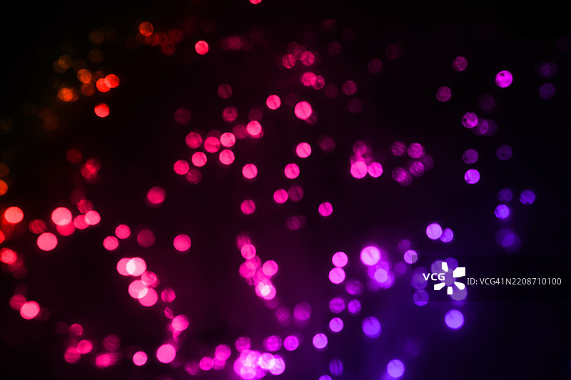 色彩斑斓的抽象散景灯光映衬在黑暗背景上图片素材