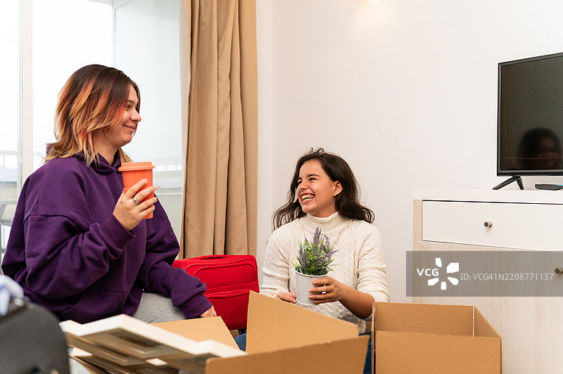 两位年轻女性在搬入新公寓时休息片刻图片素材
