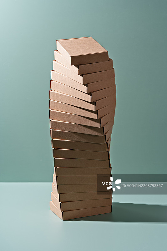 绿色背景上的纸箱螺旋堆叠图片素材