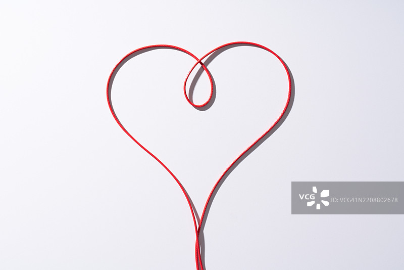 白色背景上的红色心形与红绳图片素材