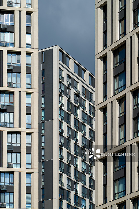 现代住宅建筑在基辅的城市景观中展示独特设计，背景是戏剧性的天空。图片素材