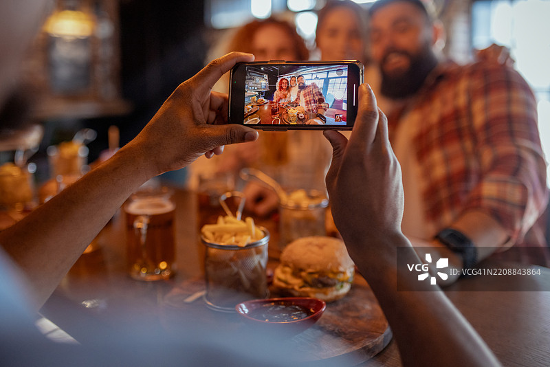 科技感十足的团聚：智能手机记录餐厅的快乐时光图片素材