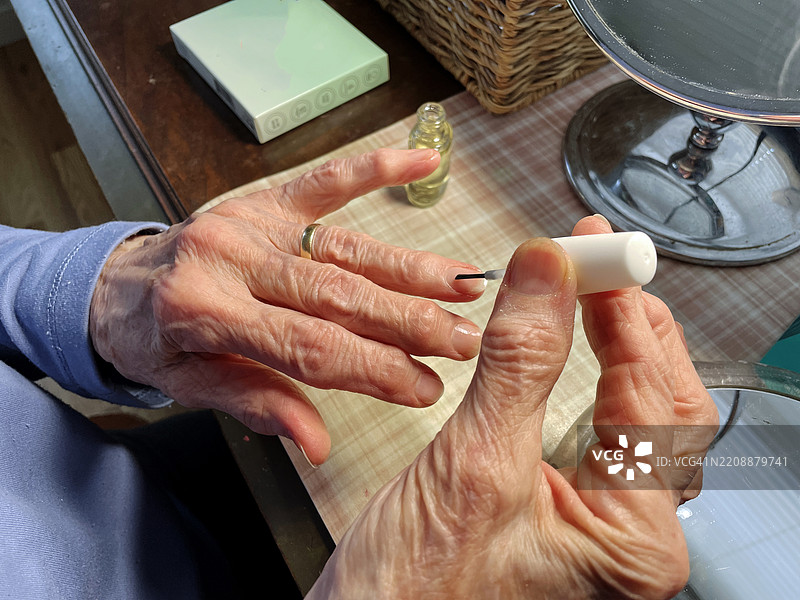 一位年长女性在涂指甲油图片素材