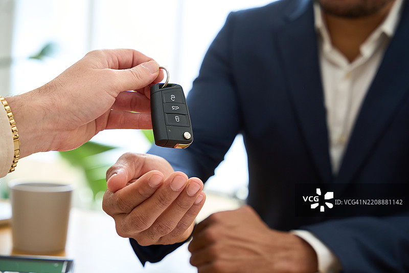 金融顾问在成功批准贷款后将车钥匙交给客户图片素材