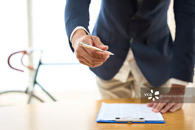 金融顾问在共享办公空间递交签约用的笔图片素材