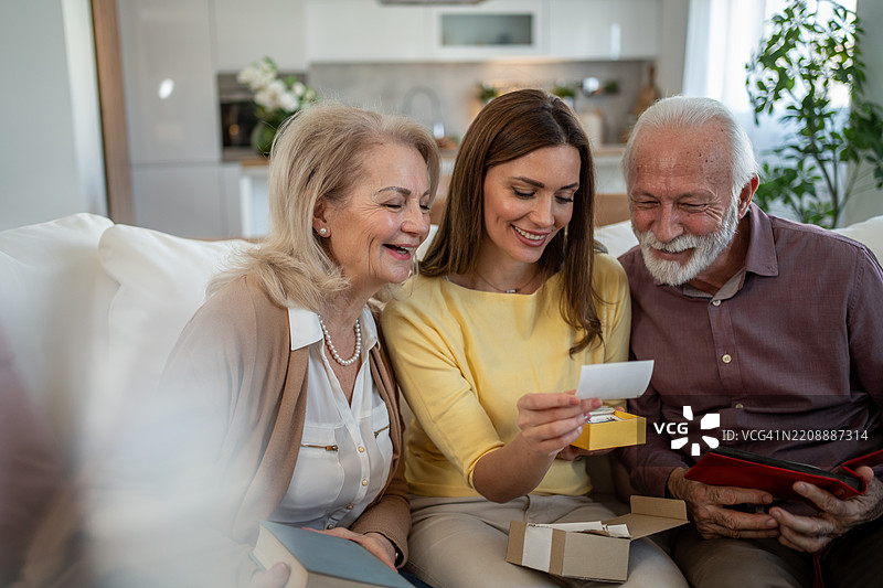 快乐的家庭在家中翻看旧照片图片素材