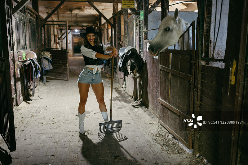 骄傲地站在马旁的女牛仔图片素材
